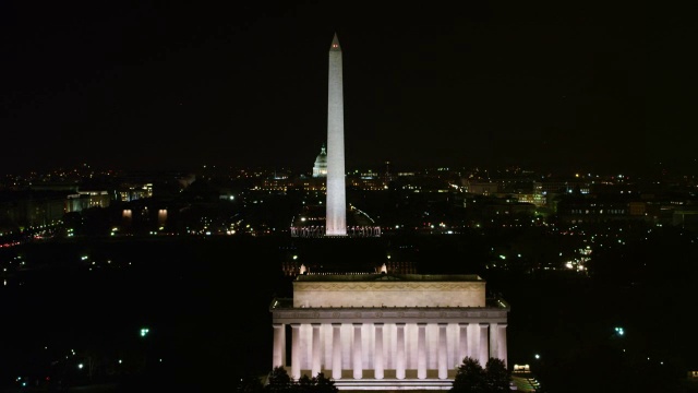 华盛顿纪念碑的夜景与远处的国会大厦，林肯纪念堂通过画面从左到右。2011年拍摄的。视频素材