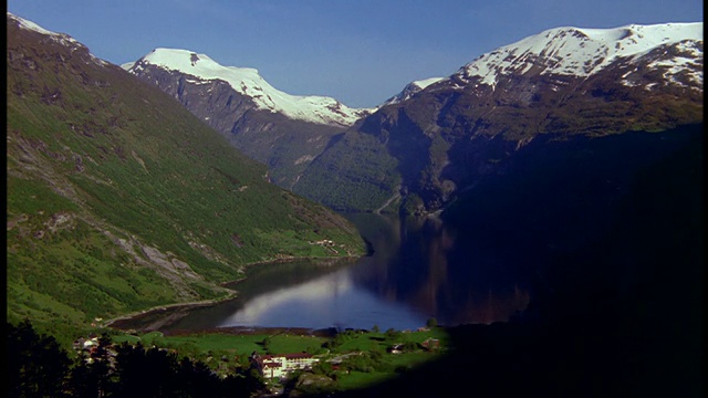 宽镜头时间推移阴影与河流+山脉+村庄/ Geiranger峡湾/ Romsdal，挪威视频素材