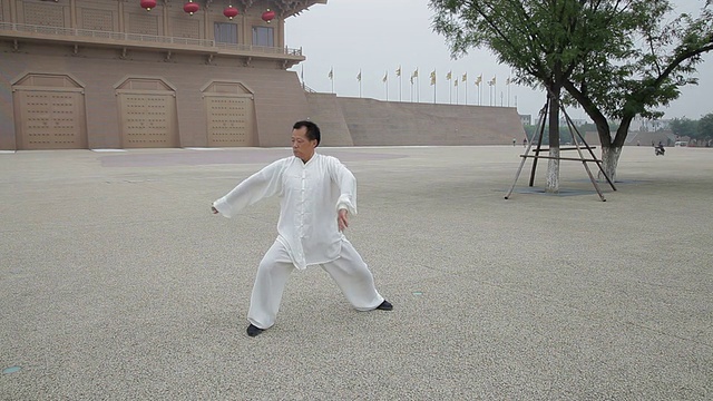 中国陕西西安，在中国建筑前打太极的女士视频素材