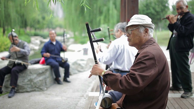 在中国陕西西安的公园里，一位老人在演奏中国传统乐器(二胡和板胡)视频素材