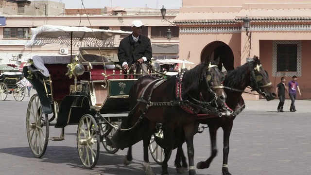 这是在摩洛哥马拉喀什的Djemaa El Fnaa大街和市场上行走的人们视频素材