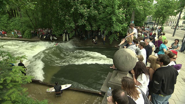 英国花园- Eisbach，在桥上的观众，冲浪板，树，水视频素材