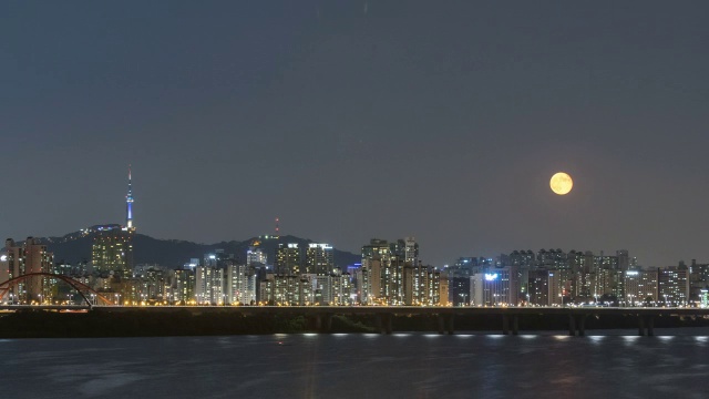 夜景有许多建筑物和南山塔，月亮从汉江升起在天空中视频素材