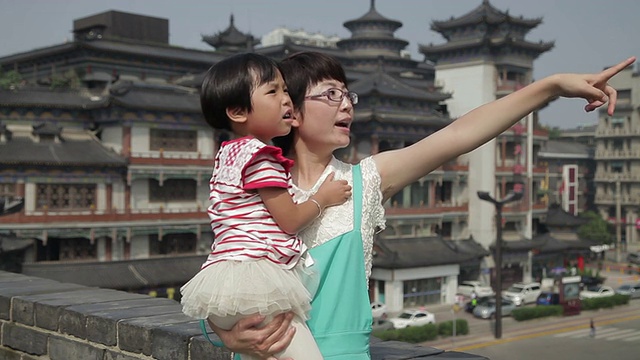 母女在中国古典建筑前交谈。视频素材