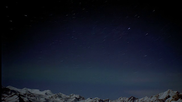 宽镜头延时拍摄在雪山上的北极光夜晚的星场/阿拉斯加视频素材