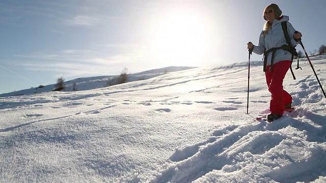 穿雪鞋下山的女人视频素材