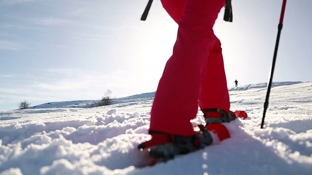 穿雪鞋上山的女人视频素材