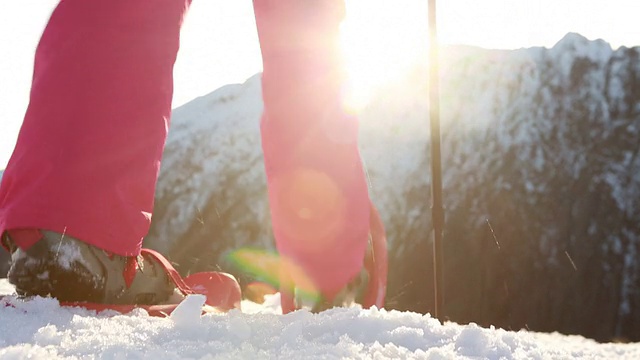 日落时分，女人穿着雪鞋上山视频素材