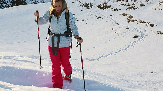 日落时分，女人穿着雪鞋上山视频素材