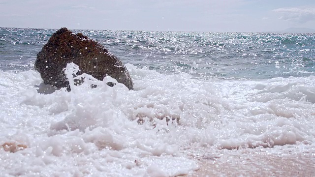 慢动作海浪粉碎在海滩上的岩石视频素材