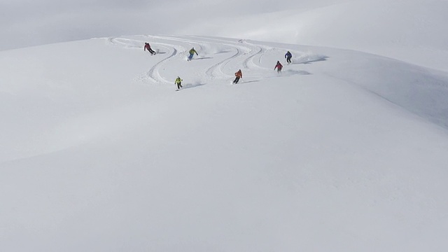 一群人在白雪覆盖的山上用直升机滑雪。慢动作——以240帧/秒的速度拍摄视频素材