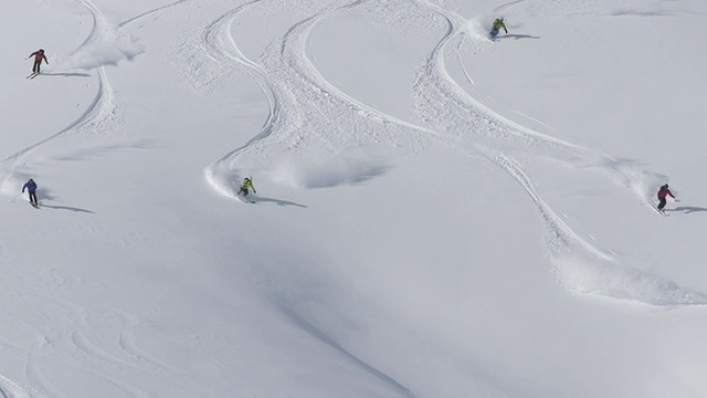 一群人在白雪覆盖的山上用直升机滑雪。慢动作——以240帧/秒的速度拍摄视频素材