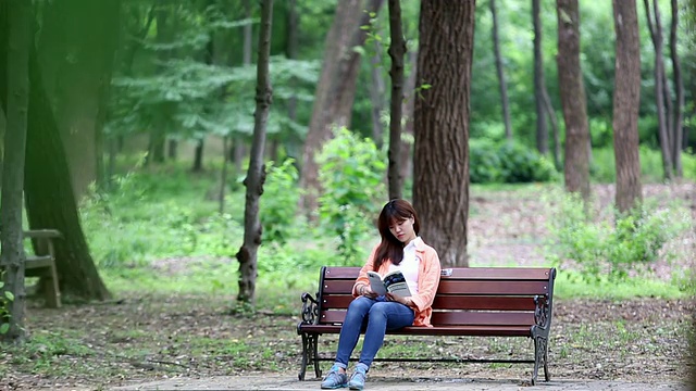 一名女子在汉城的朝鲜王朝国王墓公园看书视频素材