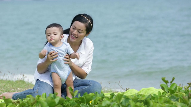 妈妈和她的孩子在海边玩。视频素材