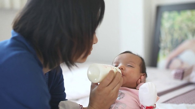 妈妈在房子里给她的婴儿喂奶视频素材