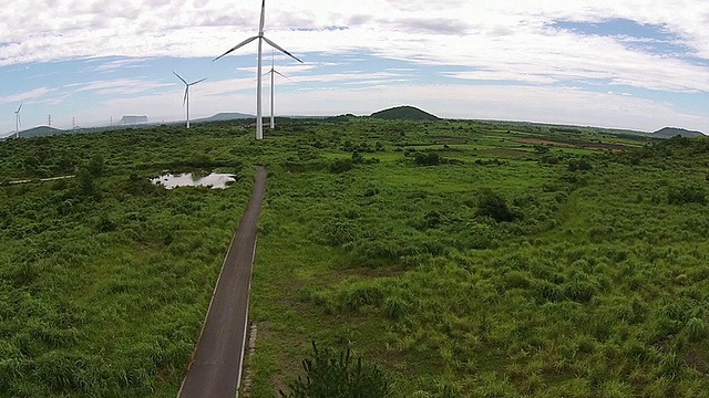 在Seongsanilchulbong的Jejuolle道路和垂直轴风力涡轮机的观点视频素材