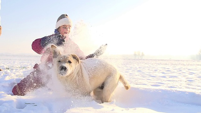 小女孩在雪地里和小狗玩视频素材