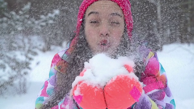 女孩把雪吹向相机视频素材