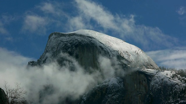 加州约塞米蒂国家公园的约塞米蒂山谷，被雪覆盖的半圆顶和漩涡云的TL, MS视频素材