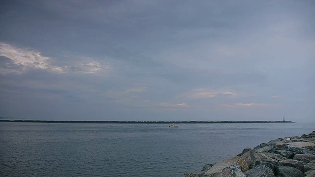 小船出海，码头在前景与半岛与灯塔的背景，多云，蓝色的早晨，梅里马克河，梅李岛。麻萨诸塞州视频素材