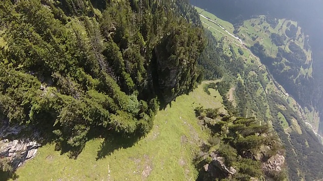 翼装飞行员的POV，从山谷上方的悬崖上飞下来视频素材