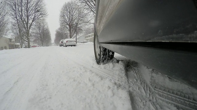 车辆在雪地里行驶，前轮的雪飞向镜头视频素材