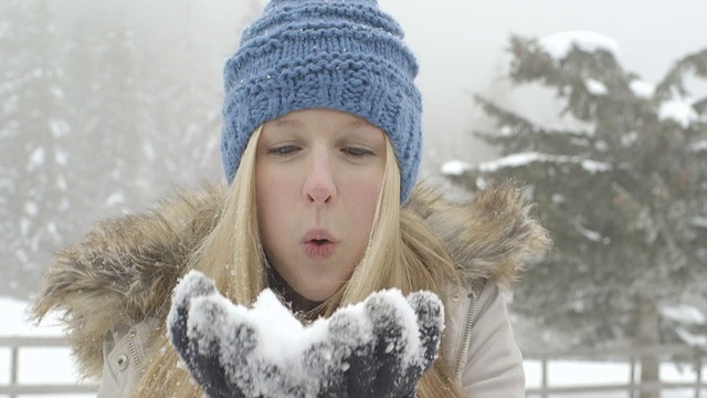 年轻女子享受着飘雪的冬天视频素材