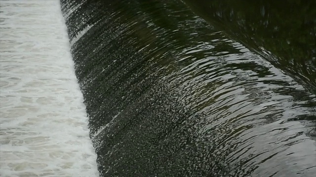 大雨过后，在一个低水头的水坝上，湍急的水流溢出视频素材