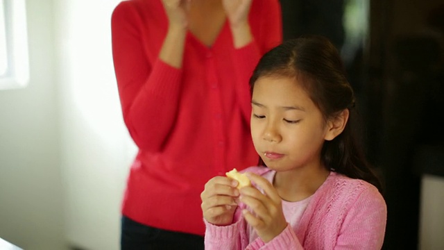 母亲和女儿正在吃新鲜做的饼干视频素材