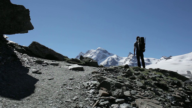 登山者在欧洲阿尔卑斯山的岩石悬崖上行走视频素材