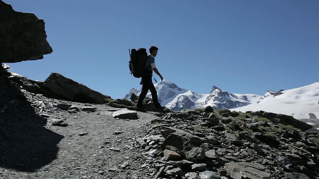 登山者在欧洲阿尔卑斯山的岩石悬崖上行走视频素材