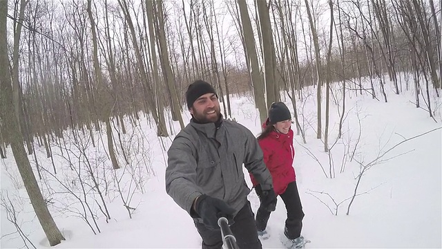 穿着雪鞋在雪地里跑步的夫妇视频素材