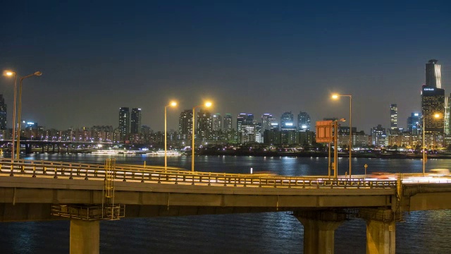 江边本诺公路上的交通夜景和汉江上的悠ido摩天大楼视频素材