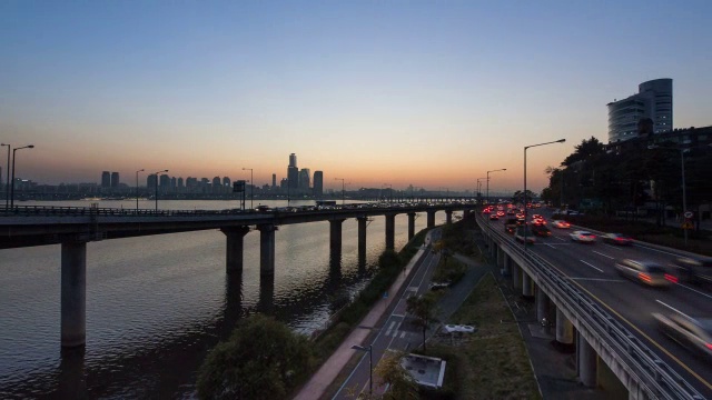 日落到夜晚，江边高速公路上的交通和汉江上的Yeouido摩天大楼视频素材