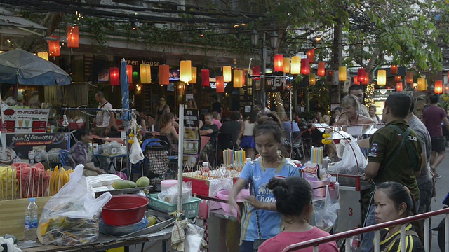 游客走在曼谷旅游区有餐馆和街头小贩的街道上视频素材