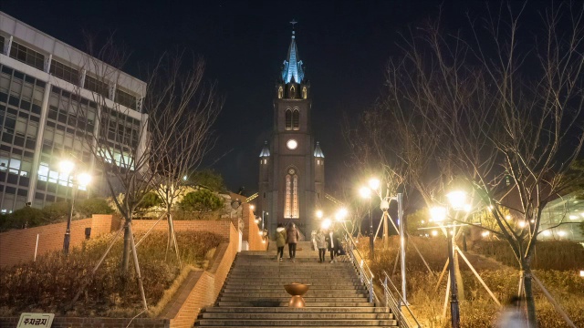 人们在明洞大教堂的台阶上上下走动的夜景视频素材