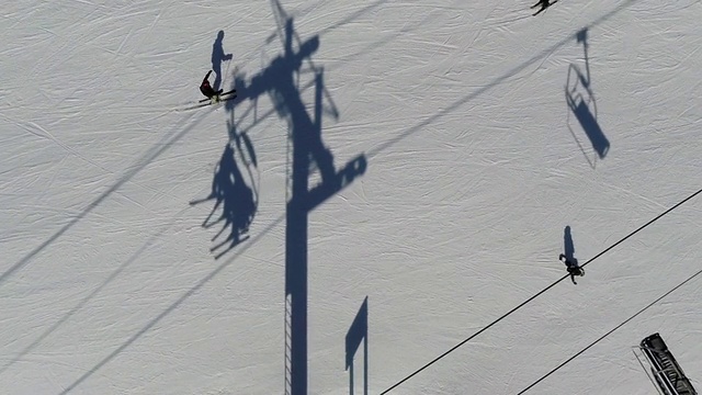 正上方拍摄的人们在滑雪缆车下面滑雪视频素材