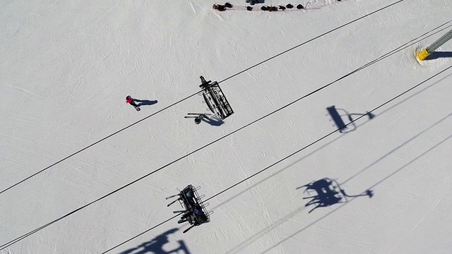 正上方拍摄的人们在滑雪缆车下面滑雪视频素材