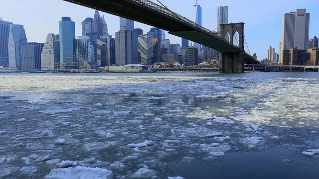 图为东河布鲁克林大桥下的浮冰。布鲁克林大桥后面可以看到曼哈顿市中心的摩天大楼。视频素材