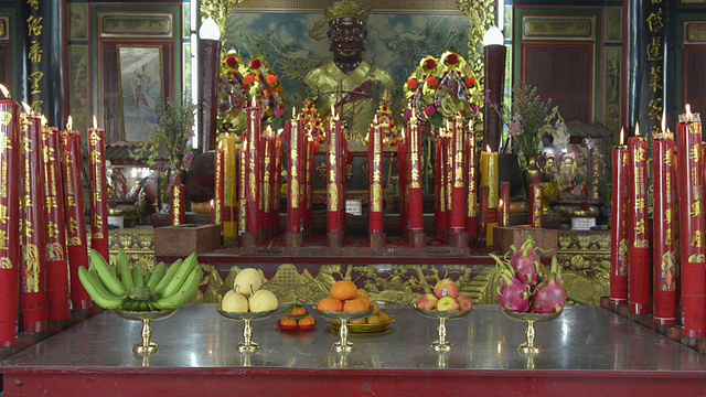 祭品和蜡烛在中国寺庙的祭坛上燃烧视频素材