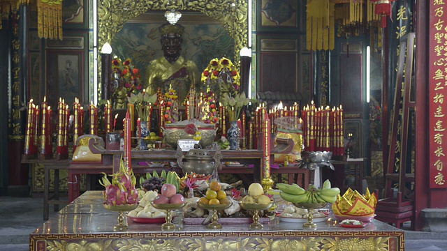 祭品和蜡烛在中国寺庙的祭坛上燃烧视频素材