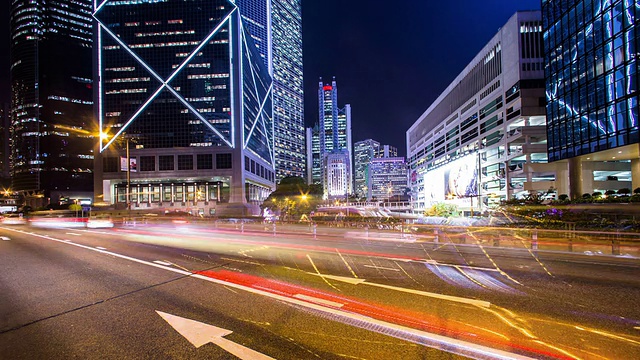 繁忙的交通，灯火通明的建筑物和街道在夜晚的现代城市香港，时间流逝。视频素材