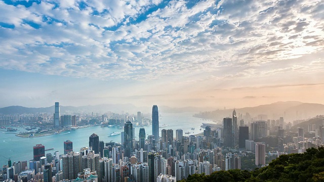 时间流逝，香港天际线和维多利亚港沐浴在清晨的阳光视频素材