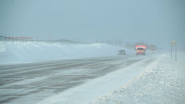 冬季暴风雪与吹雪横跨高速公路和救护车视频素材