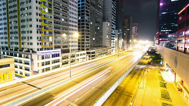 繁忙的交通，灯火通明的建筑物和街道在夜晚的现代城市香港，时间流逝。视频素材