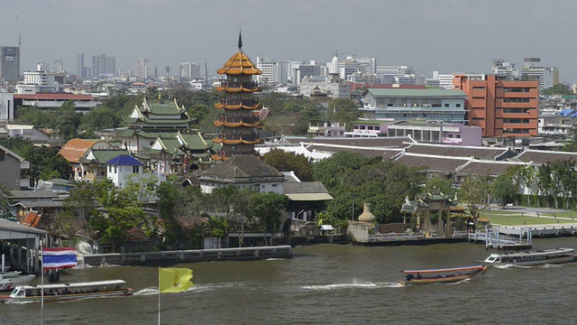 快船和长尾船经过湄南河上的一座寺庙视频素材