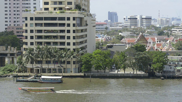 长尾船在湄南河与酒店建筑视频素材