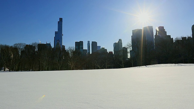 PAN相机捕捉到了雪地上的绵羊草地和曼哈顿摩天大楼上方的太阳。视频素材