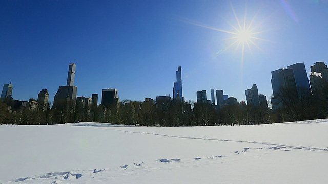 PAN相机捕捉到了雪地上的绵羊草地和曼哈顿摩天大楼上方的太阳。视频素材