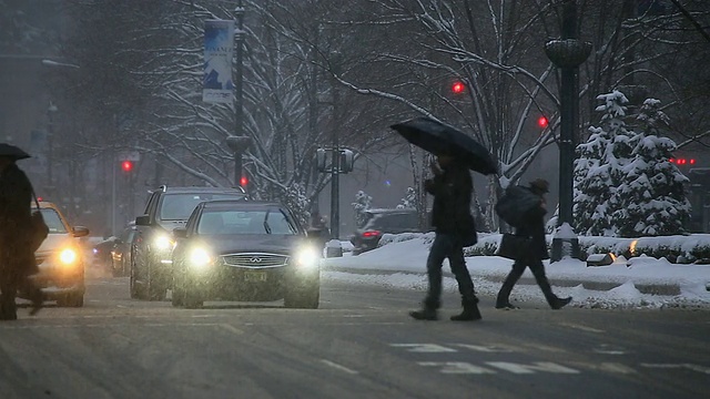 PAN摄像机拍摄下了曼哈顿中城的交通和通勤者在下雪的时候在公园大道。视频素材